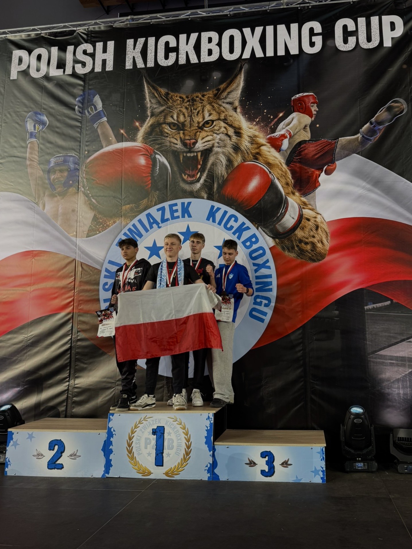 Podium Polish Kickboxing Cup — zawodnicy z flagą Polski